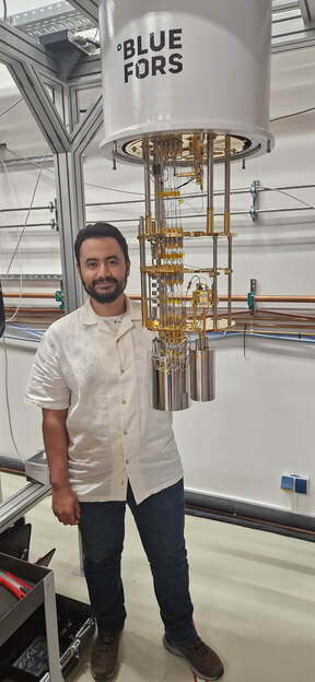 Zakaria Mzaouali beside a Bluefors dilution refrigerator